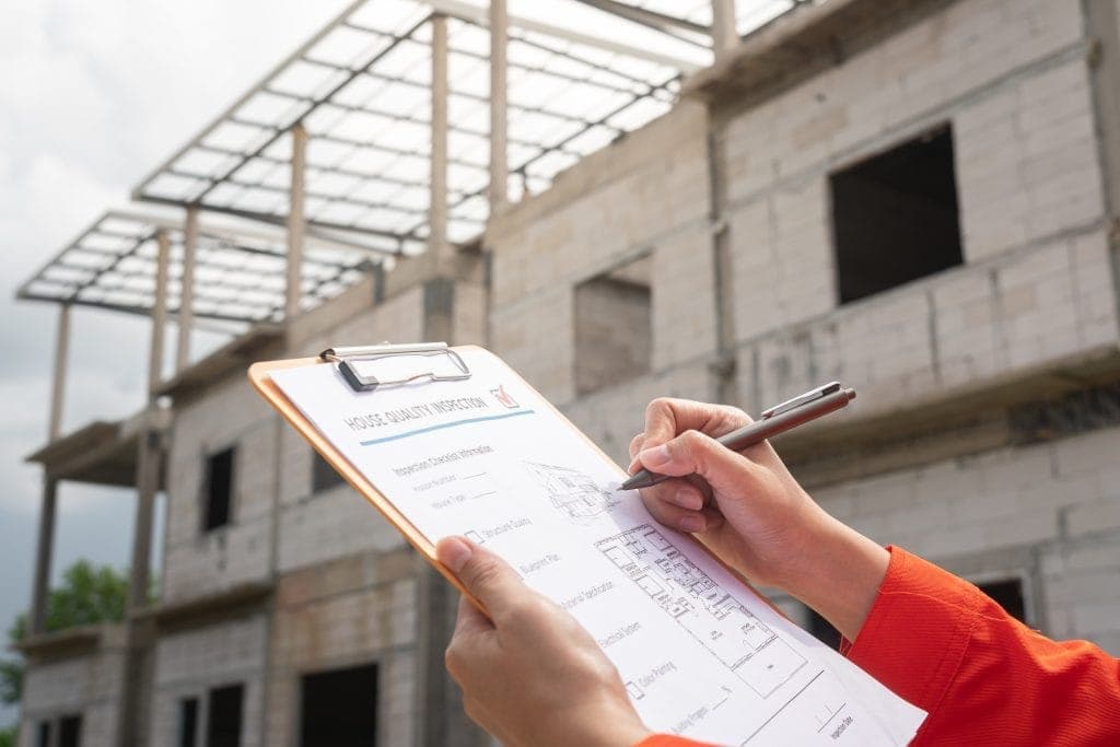建筑工地,工程师或检查员在房屋质量检查表上记录笔记