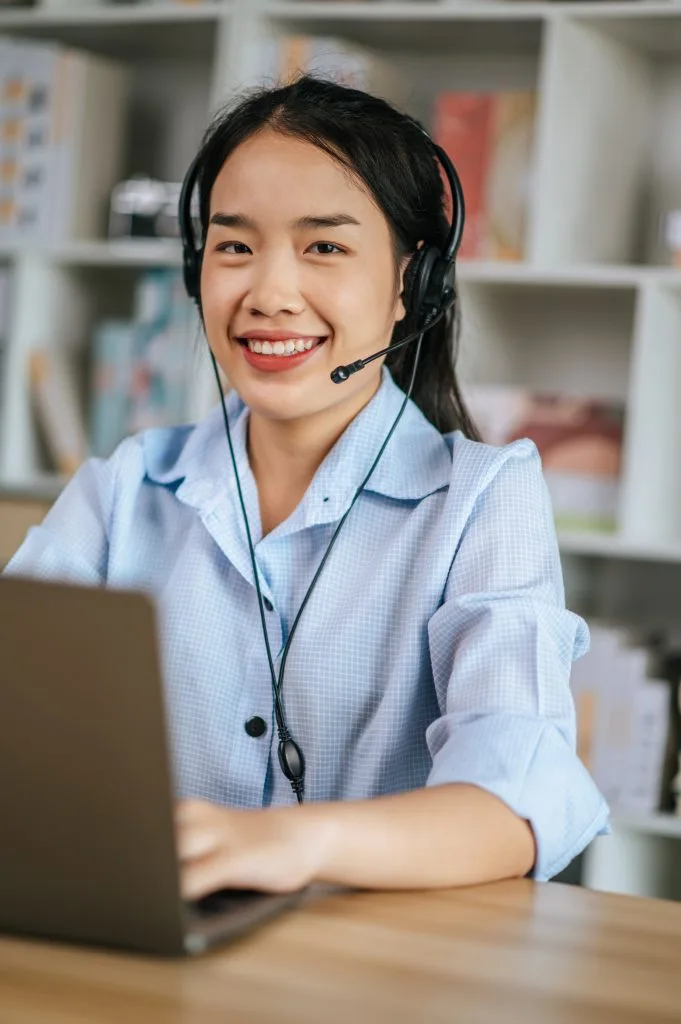 Friendly customer support agent assisting real estate clients in Phuket, providing property management and investment guidance.